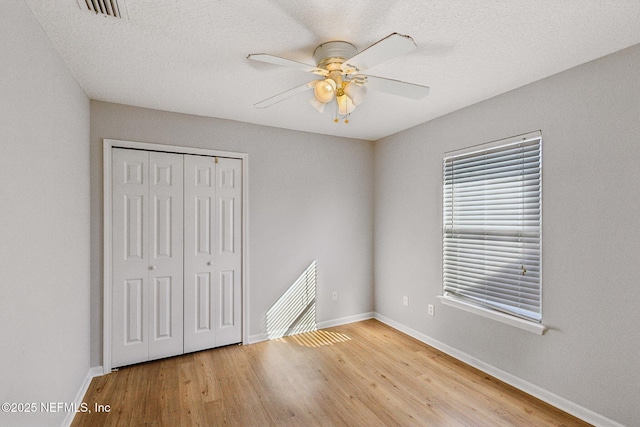 2423 Royal Pointe Dr, Green Cove Springs, FL 32043 - unfurnished bedroom with visible vents, a closet, baseboards, ceiling fan, and wood finished floors