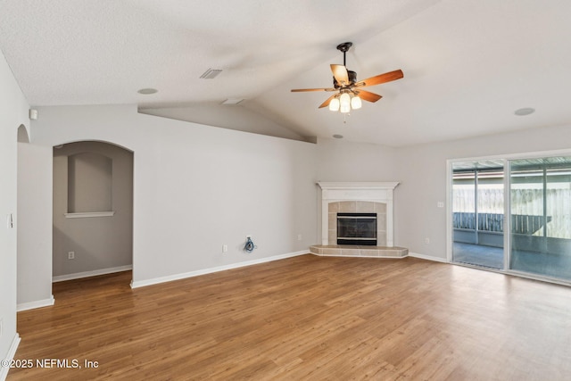 2423 Royal Pointe Dr, Green Cove Springs, FL 32043 - unfurnished living room with a tile fireplace, light wood-style floors, vaulted ceiling, and ceiling fan