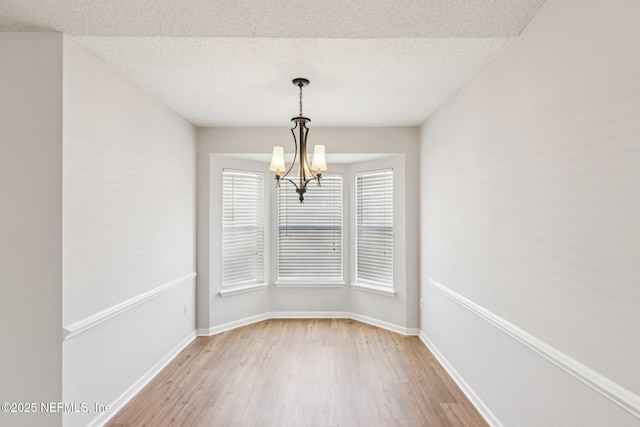 2423 Royal Pointe Dr, Green Cove Springs, FL 32043 - spare room featuring a notable chandelier, light wood-style flooring, and baseboards