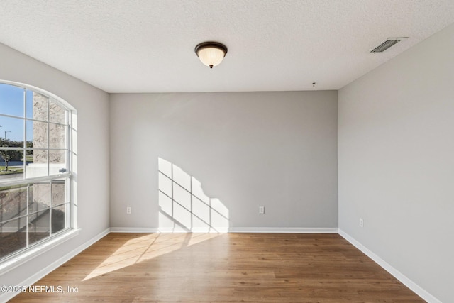 2423 Royal Pointe Dr, Green Cove Springs, FL 32043 - unfurnished room featuring visible vents, baseboards, wood finished floors, and a textured ceiling