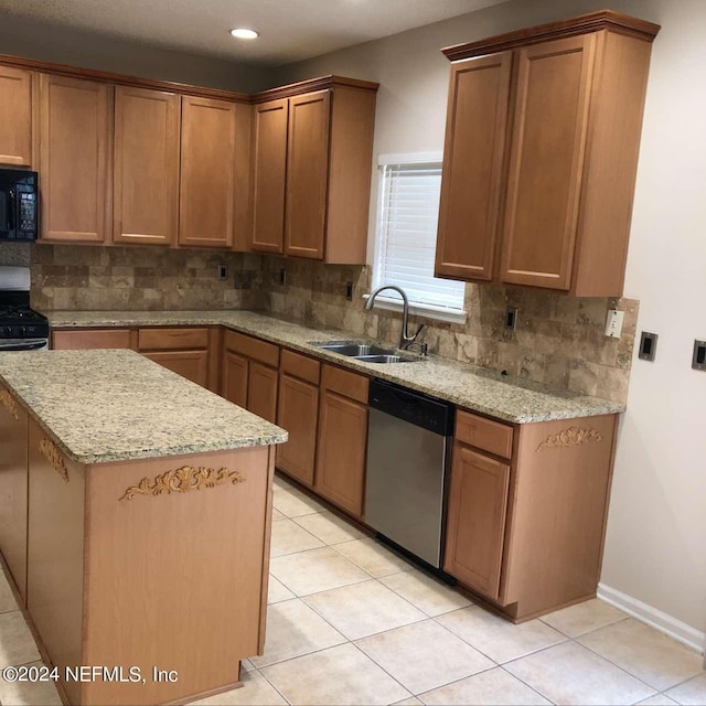 kitchen featuring appliances with stainless steel finishes, backsplash, a kitchen island, and a sink