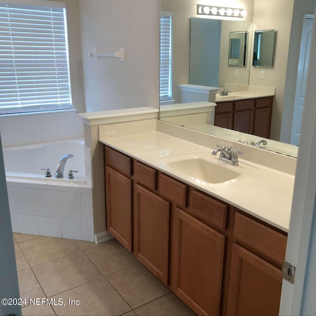 bathroom featuring a bath, two vanities, a sink, and tile patterned floors