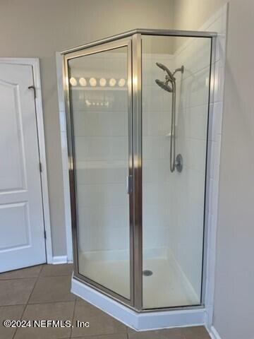 bathroom with tile patterned floors and a shower stall