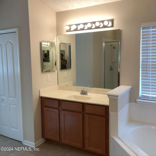 bathroom featuring tile patterned floors, a shower stall, a bath, and vanity
