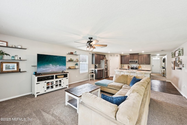 living room featuring carpet floors, a ceiling fan, baseboards, and recessed lighting