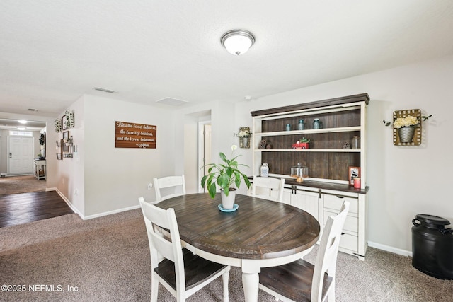dining room featuring baseboards, visible vents, and light colored carpet