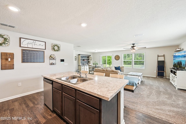 kitchen with light countertops, a textured ceiling, a sink, and dishwasher