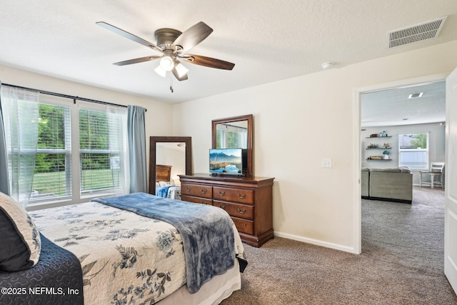 bedroom featuring carpet floors, baseboards, visible vents, and multiple windows