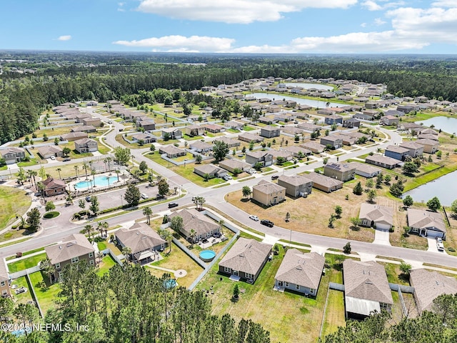 birds eye view of property with a water view, a view of trees, and a residential view