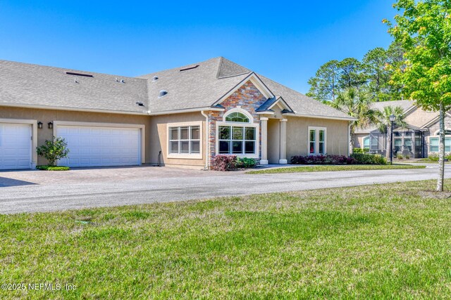 86 Amacano Ln, Saint Augustine, FL 32084 - view of front of house featuring driveway, a front yard, stucco siding, and a garage