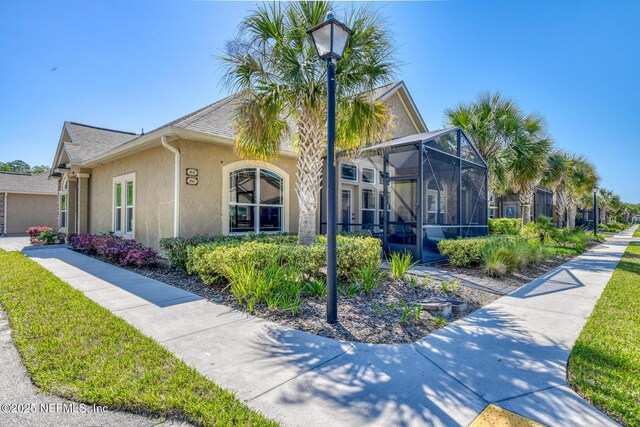 86 Amacano Ln, Saint Augustine, FL 32084 - view of front facade with roof with shingles, stucco siding, and a lanai