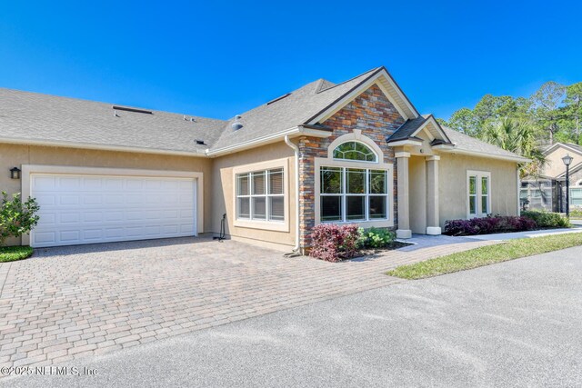 86 Amacano Ln, Saint Augustine, FL 32084 - ranch-style home with driveway, a garage, stone siding, and stucco siding