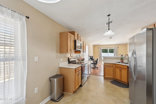3620 Braeden Ct, Middleburg, FL 32068 - kitchen with a textured ceiling, appliances with stainless steel finishes, light countertops, a sink, and decorative light fixtures