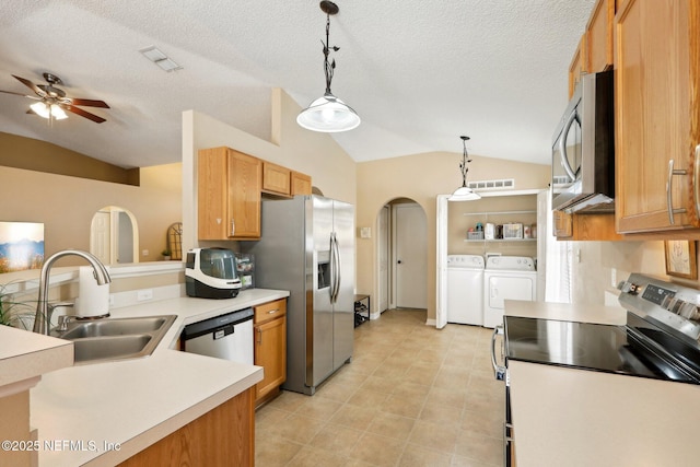 3620 Braeden Ct, Middleburg, FL 32068 - kitchen with independent washer and dryer, arched walkways, vaulted ceiling, appliances with stainless steel finishes, and a sink