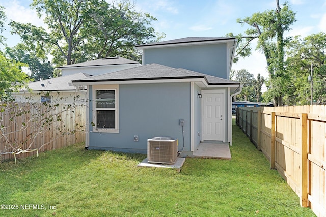 7609 Eaton Ave, Jacksonville, FL 32211 - back of property with a shingled roof, a fenced backyard, central AC unit, and a lawn