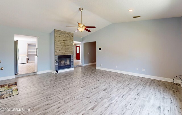4147 Saunders Dr, Middleburg, FL 32068 - unfurnished living room with vaulted ceiling, wood finished floors, visible vents, a ceiling fan, and a multi sided fireplace