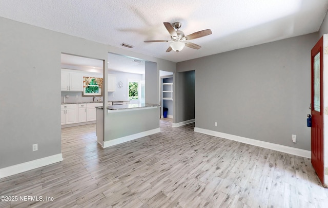 4147 Saunders Dr, Middleburg, FL 32068 - unfurnished living room with light wood finished floors, visible vents, a ceiling fan, and baseboards