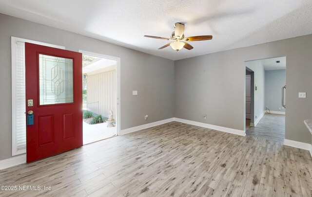 4147 Saunders Dr, Middleburg, FL 32068 - foyer entrance with light wood-type flooring, a textured ceiling, a ceiling fan, and baseboards