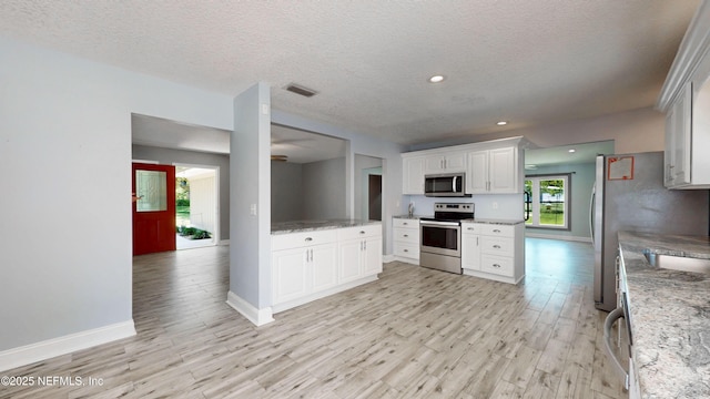 4147 Saunders Dr, Middleburg, FL 32068 - kitchen with visible vents, stainless steel appliances, baseboards, and light wood-style floors