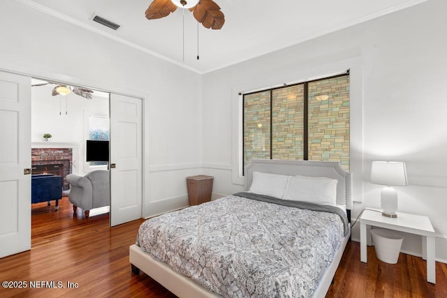 4215 Irvington Ave, Jacksonville, FL 32210 - bedroom with ceiling fan, a fireplace, ornamental molding, visible vents, and wood finished floors