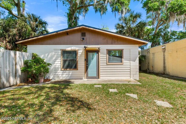 4215 Irvington Ave, Jacksonville, FL 32210 - back of house featuring a fenced backyard and a lawn