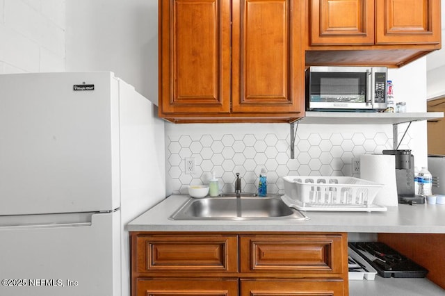 4215 Irvington Ave, Jacksonville, FL 32210 - kitchen with a sink, light countertops, freestanding refrigerator, stainless steel microwave, and backsplash