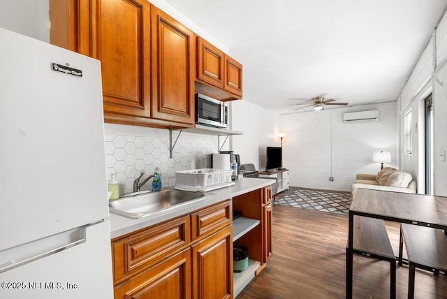4215 Irvington Ave, Jacksonville, FL 32210 - kitchen featuring ceiling fan, freestanding refrigerator, a wall unit AC, dark wood-style flooring, and a sink
