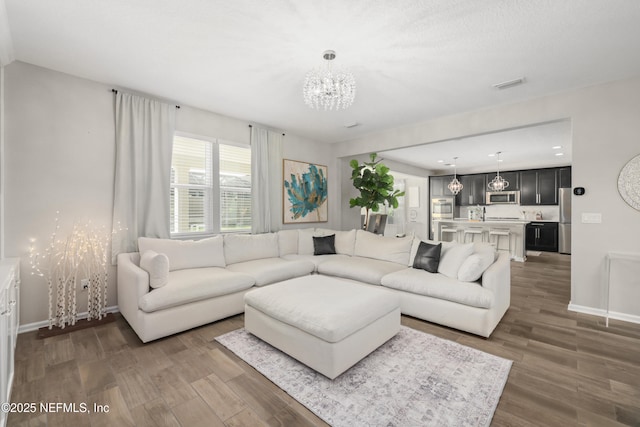 190 Palisade Dr, Saint Augustine, FL 32092 - living area featuring dark wood-style flooring, a notable chandelier, visible vents, and baseboards