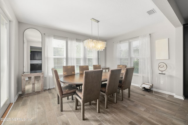 190 Palisade Dr, Saint Augustine, FL 32092 - dining area with light wood-type flooring, visible vents, a healthy amount of sunlight, and an inviting chandelier