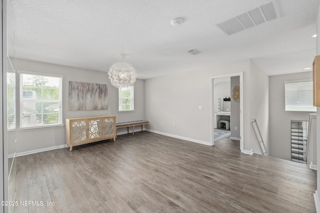 190 Palisade Dr, Saint Augustine, FL 32092 - unfurnished living room with a chandelier, wood finished floors, visible vents, and plenty of natural light