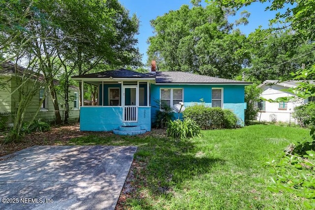 2969 Green St, Jacksonville, FL 32205 - view of front of property featuring a sunroom, roof with shingles, a chimney, and a front lawn