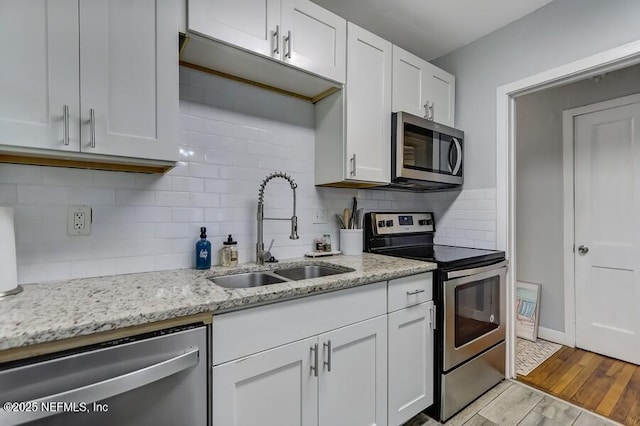 2969 Green St, Jacksonville, FL 32205 - kitchen with stainless steel appliances, tasteful backsplash, white cabinetry, and a sink