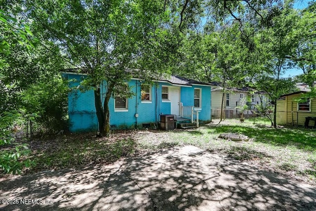 2969 Green St, Jacksonville, FL 32205 - rear view of house featuring crawl space, cooling unit, fence, and brick siding