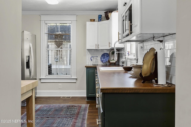 73 Weeden St, Saint Augustine, FL 32084 - kitchen with stainless steel fridge with ice dispenser, dark wood-style flooring, baseboards, white cabinets, and a sink