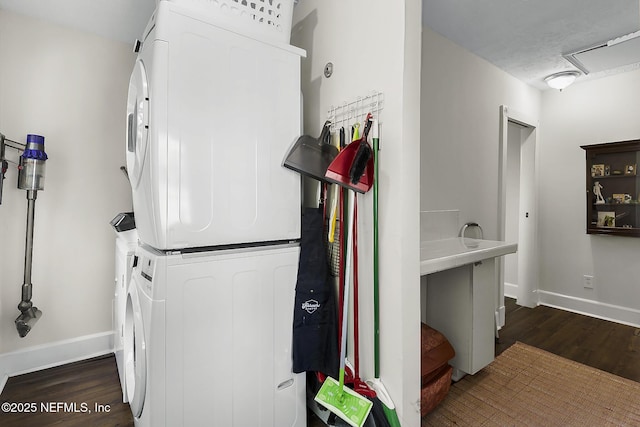 73 Weeden St, Saint Augustine, FL 32084 - washroom with dark wood-type flooring, baseboards, stacked washing maching and dryer, and laundry area