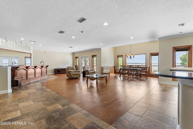 living room with crown molding, visible vents, and recessed lighting