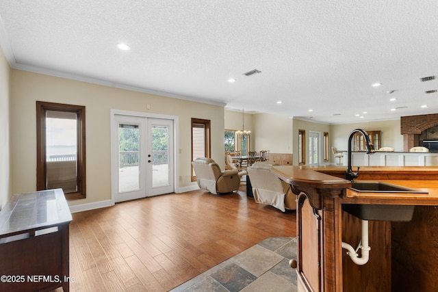 interior space with open floor plan, visible vents, a textured ceiling, and recessed lighting