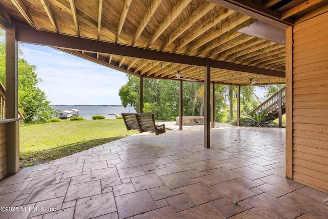 view of patio / terrace featuring a water view and stairway