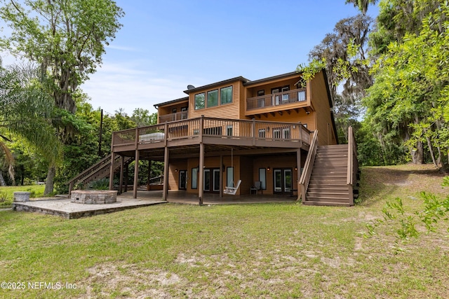 rear view of property with a lawn, a wooden deck, a patio, and stairs
