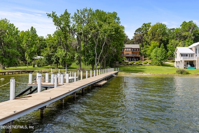 view of dock featuring a lawn and a water view