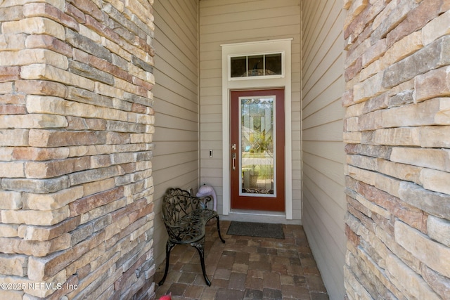 view of exterior entry featuring stone siding