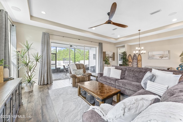 380 Maralinda Dr, Saint Augustine, FL 32095 - living room featuring visible vents, a raised ceiling, recessed lighting, wood finished floors, and ceiling fan with notable chandelier