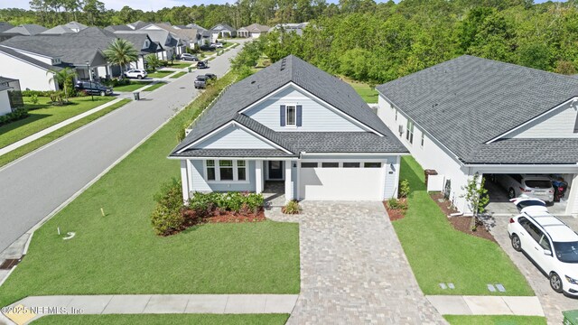 380 Maralinda Dr, Saint Augustine, FL 32095 - view of front facade with a front yard, a residential view, a garage, and decorative driveway