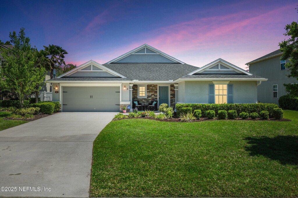 62 Little Harbour Way, Saint Augustine, FL 32092 - craftsman inspired home featuring a front lawn, stucco siding, an attached garage, driveway, and stone siding