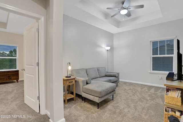 1133 Laurel Valley Dr, Orange Park, FL 32065 - living area featuring ceiling fan, baseboards, a tray ceiling, and light colored carpet
