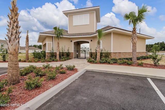 95210 Leafcrest Ct, Fernandina Beach, FL 32034 - view of front facade featuring a gate, stone siding, stucco siding, and fence
