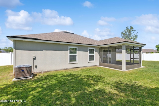 95210 Leafcrest Ct, Fernandina Beach, FL 32034 - rear view of property with central AC unit, fence, a yard, stucco siding, and a sunroom