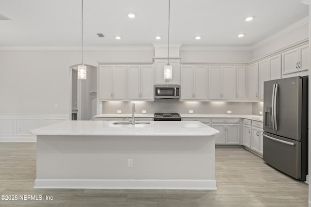121 Oxford Estates Way, Saint Johns, FL 32259 - kitchen with stainless steel appliances, a center island with sink, ornamental molding, and a sink