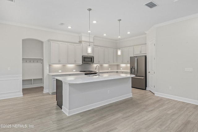 121 Oxford Estates Way, Saint Johns, FL 32259 - kitchen featuring a kitchen island with sink, light wood finished floors, appliances with stainless steel finishes, and light countertops