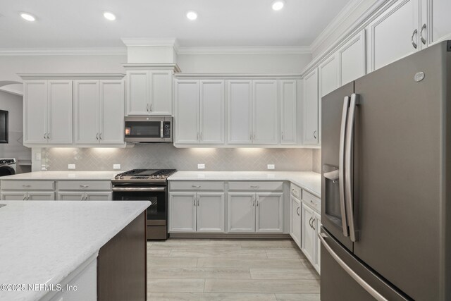 121 Oxford Estates Way, Saint Johns, FL 32259 - kitchen featuring stainless steel appliances, light countertops, ornamental molding, and white cabinets